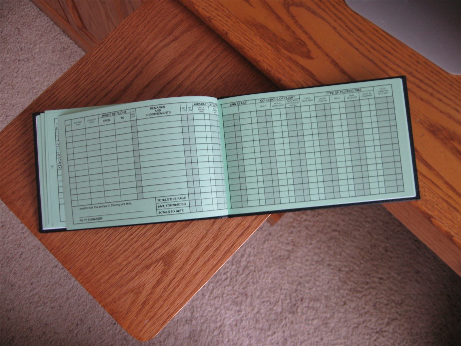 A pilot logbook and pen, the record of the checkride pass or first solo that can leave a pilot flying the next lesson on emotion rather than judgement