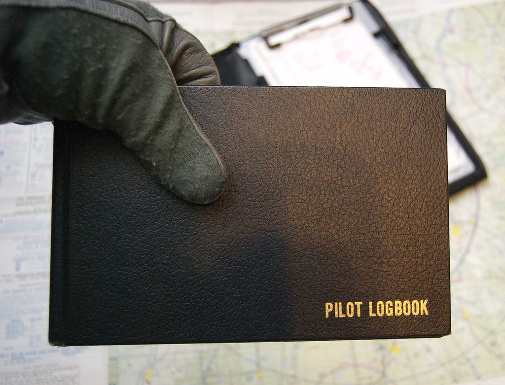 A pilot working through a pre-flight checklist in the cockpit, the moment the E in PAVE asks a pilot to name every pressure acting on the decision to fly